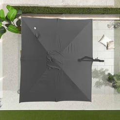 Portable dark gray patio umbrella for outdoor garden setting, sun protection, and shade creation.