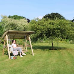 Spacious backyard with a wooden garden swing amid lush greenery, perfect for relaxing outdoors and enjoying nature. Ideal for garden furniture, outdoor leisure, and landscaping enthusiasts.