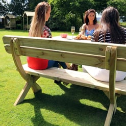 Rustic wooden outdoor bench in a lush garden, perfect for entertaining, relaxing, and enjoying the sunshine. A delightful garden furniture piece for your backyard oasis.