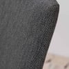 Upholstered dark gray woven fabric, close-up view of furniture showing texture and craftsmanship.