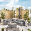 Outdoor patio furniture with modern sectional sofa, decorative pillows, and ambient lighting in a stylish backyard courtyard. Perfect for outdoor entertaining and relaxing.