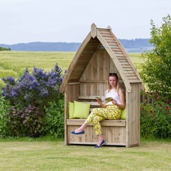 Handcrafted wooden garden shed with cozy sitting area, surrounded by lush greenery and vibrant flowers, perfect for outdoor relaxation and garden storage.