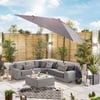 Stylish outdoor patio with gray sectional sofa, umbrella, decorative pillows, and lush plants, perfect for outdoor living and garden entertaining.