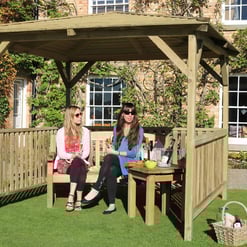 Relaxing outdoor wooden gazebo in a garden setting with two women enjoying drinks, perfect for outdoor entertaining and garden decor.