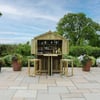 Outdoor wooden bar with bar stools on patio, surrounded by lush garden and potted plants, ideal for backyard entertaining and outdoor living.