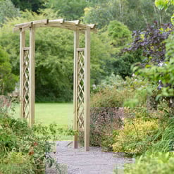 Wood garden arbor surrounded by lush greenery and colorful flowering plants, ideal for enhancing outdoor landscapes and garden spaces.