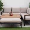 Stylish outdoor patio seating area with modern sectional sofa, cozy cushions, and decorative plants, perfect for garden relaxation and backyard entertaining.