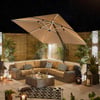 Outdoor patio furniture under large beige umbrella with string lights and potted plants, perfect for garden relaxation and outdoor living spaces.