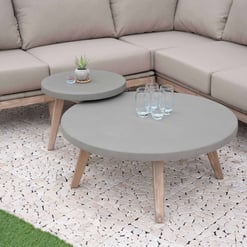 Modern outdoor patio furniture with round concrete coffee tables and a comfortable beige sectional sofa, ideal for outdoor living spaces and garden entertainment.