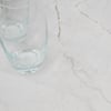 Clear drinking glasses on a light marble countertop, showcasing elegant kitchenware and modern home decor accents.