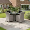 Stylish outdoor dining set with wicker chairs and a round table on a landscaped garden patio, perfect for outdoor entertaining and relaxing in a backyard oasis.