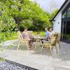 Elegant outdoor patio with wooden dining furniture, surrounded by lush green trees and garden landscaping, perfect for outdoor living and entertaining.