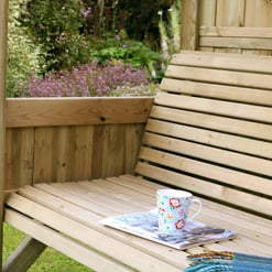 Relaxing garden wooden swing with cup of coffee and magazine overlooking lush greenery and colorful flowers, perfect for outdoor leisure and garden decor.