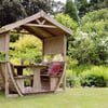 Cozy wooden garden gazebo with seating and table, perfect for outdoor relaxation and entertaining in a lush, landscaped backyard.