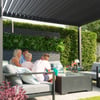 Lush vertical garden with a modern outdoor living space featuring family members enjoying a sunny day. The setting highlights outdoor furniture, cozy cushions, and stylish greenery for garden and patio enhancements.