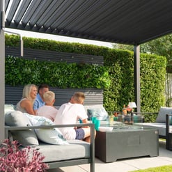 Lush vertical garden with a modern outdoor living space featuring family members enjoying a sunny day. The setting highlights outdoor furniture, cozy cushions, and stylish greenery for garden and patio enhancements.