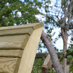 Pressure-treated wooden outdoor bench with a natural finish, set against lush green trees. Perfect for garden seating or outdoor patio decor, showcasing quality craftsmanship.