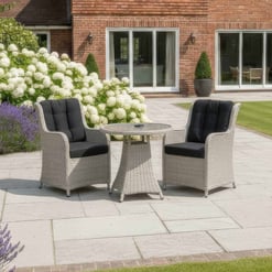 Stylish outdoor patio furniture set with two wicker chairs with black cushions and round glass-top table, perfect for garden relaxation and entertaining guests.