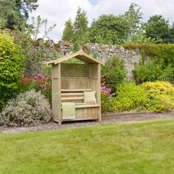 Wooden garden bench with canopy in landscaped garden with lush green plants and blooming flowers for outdoor relaxation.
