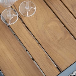 Smooth teak wood outdoor table with a contemporary metal frame for patio furniture and garden decor, perfect for outdoor entertaining.