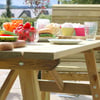 Fresh outdoor wooden dining table set with colorful breakfast foods, fruits, and beverages in a garden setting for outdoor entertaining or patio patio furniture.