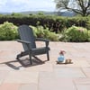 Adorable outdoor patio chair on stone paver patio with a scenic garden view and a tray of flowers and desserts.