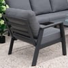 Modern outdoor patio furniture with comfortable gray cushions on a stylish black metal frame, set on a pebbled garden patio with lush greenery and potted plants, perfect for garden and backyard relaxation.