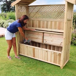 Highly detailed wooden outdoor garden storage shed installation in a lush green backyard with flowering plants, perfect for garden organization and outdoor storage solutions.