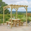 Solid wood outdoor pergola with string lights over a dining table, perfect for garden or patio entertaining in a picturesque landscape setting.
