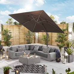 Luxurious outdoor patio with sectional sofa, large patio umbrella, and stylish decor, perfect for relaxing and entertaining in a modern garden setting.