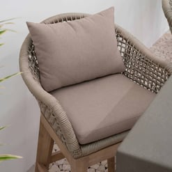 Elegant outdoor wicker armchair with beige cushions for patio or garden decor. Perfect for comfortable lounging and enhancing outdoor living spaces. Sturdy wooden frame and woven design.