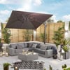 Luxurious outdoor patio with modern sectional sofa, large umbrella, decorative pillows, ambient lighting, lush potted plants, perfect for relaxing and entertaining in a stylish backyard setting.