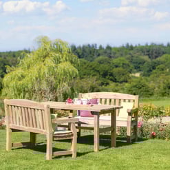 Wooden outdoor patio furniture set with garden view, teak dining table and benches, perfect for outdoor entertaining, lush green landscape backdrop, sunny spring day in backyard, Empire Home and Garden.