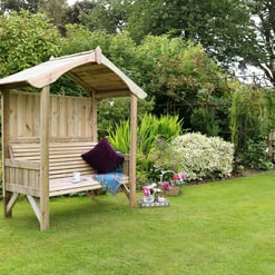 A wooden garden bench with a canopy in a lush, well-maintained backyard garden featuring vibrant flowers, green shrubs, and mature trees, perfect for outdoor relaxation and gardening.