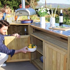 Bright outdoor kitchen with wooden cabinetry, garden scenery, and a gas grill, perfect for alfresco dining and entertaining in your home and garden.