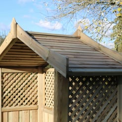 Solid wooden garden shed with lattice design and pitched roof, ideal for outdoor storage and gardening needs. Made from durable, natural wood for garden enthusiasts.