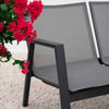 Modern outdoor patio bench with gray mesh seating and black metal frame, complemented by vibrant pink flowering plant for stylish garden and patio furniture display.