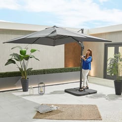 Elegant outdoor patio with a large adjustable umbrella, potted plants, and stylish decor, perfect for relaxing and entertaining in your backyard.