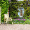 Beautiful garden seating area with wooden chair, vibrant flowers, lush greenery, and ivy-covered brick wall, perfect for outdoor home garden oasis.