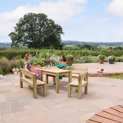 Elegant outdoor patio with wooden dining table and benches, lush garden with blooming flowers, scenic countryside view, perfect for garden furniture and outdoor entertaining.