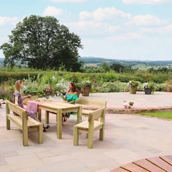 Relaxing outdoor patio with wooden furniture and vibrant potted flowers at Empire Home and Garden in a lush garden setting.