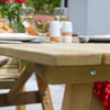 Warm wooden outdoor dining table with plates, glasses, and condiments, perfect for garden gatherings and al fresco dining, featuring natural wood finish and sturdy construction.