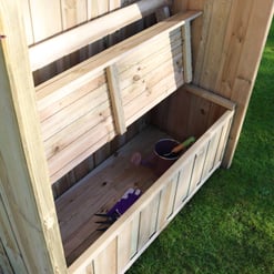 Natural wooden garden shed with planting trays and gardening tools for outdoor gardening and storage solutions.