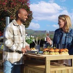 Enjoying outdoor entertaining with a backyard barbecue featuring gourmet sliders, fresh herbs, and scenic mountain views for a perfect garden gathering at Empire Home and Garden.