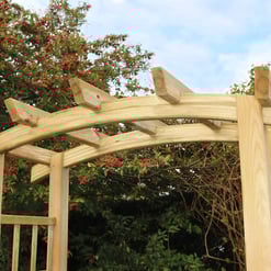 Natural wooden garden arbor with curved top arch, ideal for outdoor landscaping and welcoming yard entrances, surrounded by greenery and blooming plants.