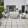 Sleek modern outdoor patio furniture set with white cushions and a matching coffee table, surrounded by potted plants, in a contemporary backyard space.