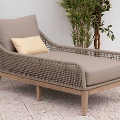 Comfortable outdoor chaise lounge with woven rattan design and plush cushions, perfect for garden patios or backyard relaxation.