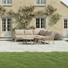 Bright outdoor patio furniture set with beige cushioned sectional sofa and wooden coffee tables, garden with blooming climbing roses, stone house exterior, perfect for garden decor and outdoor living in home and garden design.