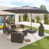 Modern outdoor patio with black furniture, fire feature, large umbrella, and lush greenery, perfect for outdoor living and entertaining, designed by Empire Home and Garden.