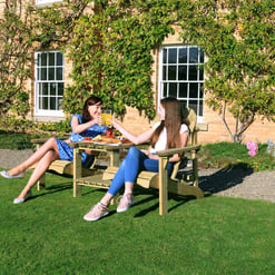 Relaxing outdoor garden scene with women enjoying a sunny day, showcasing garden furniture, lush greenery, and vibrant landscaping. Perfect for outdoor living, patio furniture, and garden decor ideas.